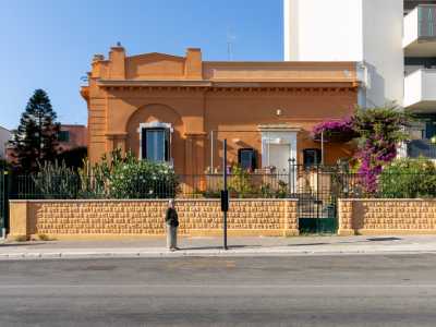 Superiamo ora dei moderni palazzi residenziali per raggiungere, sempre su via Adriatico, una graziosa residenza color salmone. Costruita nel 1929, mostra sulla facciata una finta arcata sorretta da doppie lesene e sovrastata da un elemento a timpano